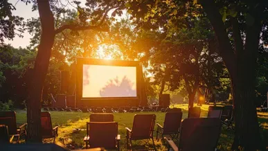 A film screen outdoors with rows of chairs.